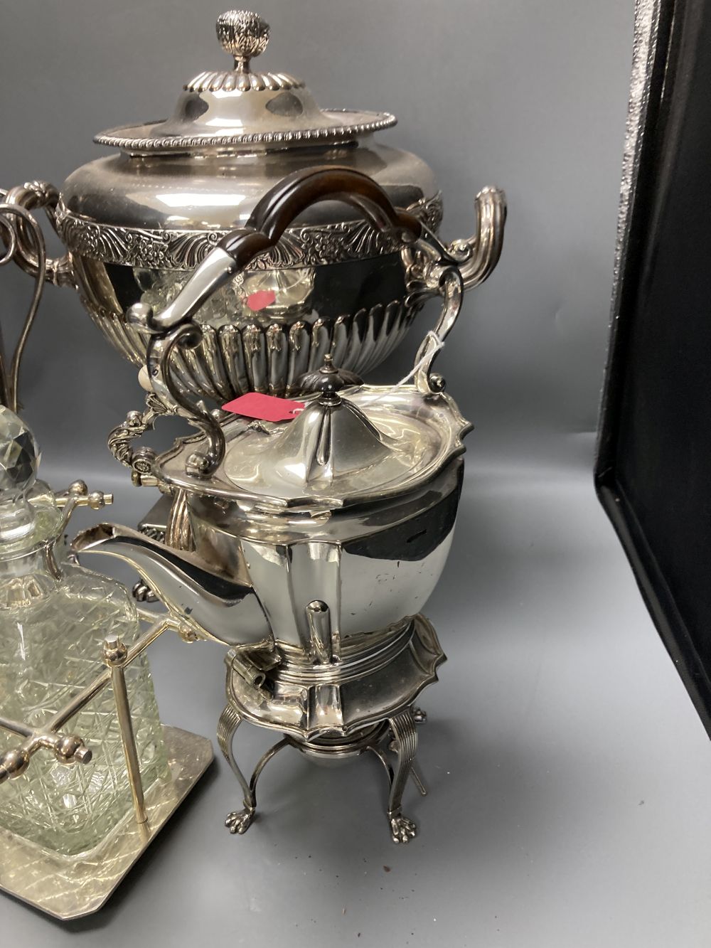 A plated samovar, a kettle on stand, a pair of vases and a three bottle silver plated tantalus and on Old Sheffield plate tea urn, c.18